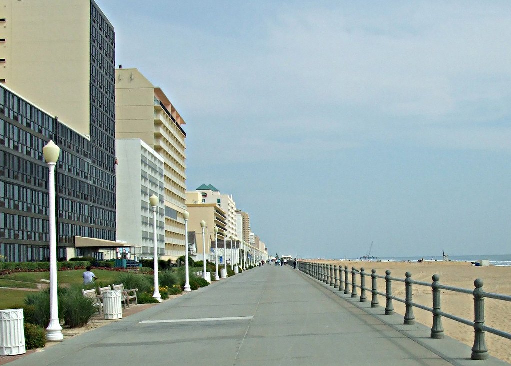 Image of a lengthy pathway along the beach lined with high-rise buildings. Pest control in Virginia Beach keeps city disease-free