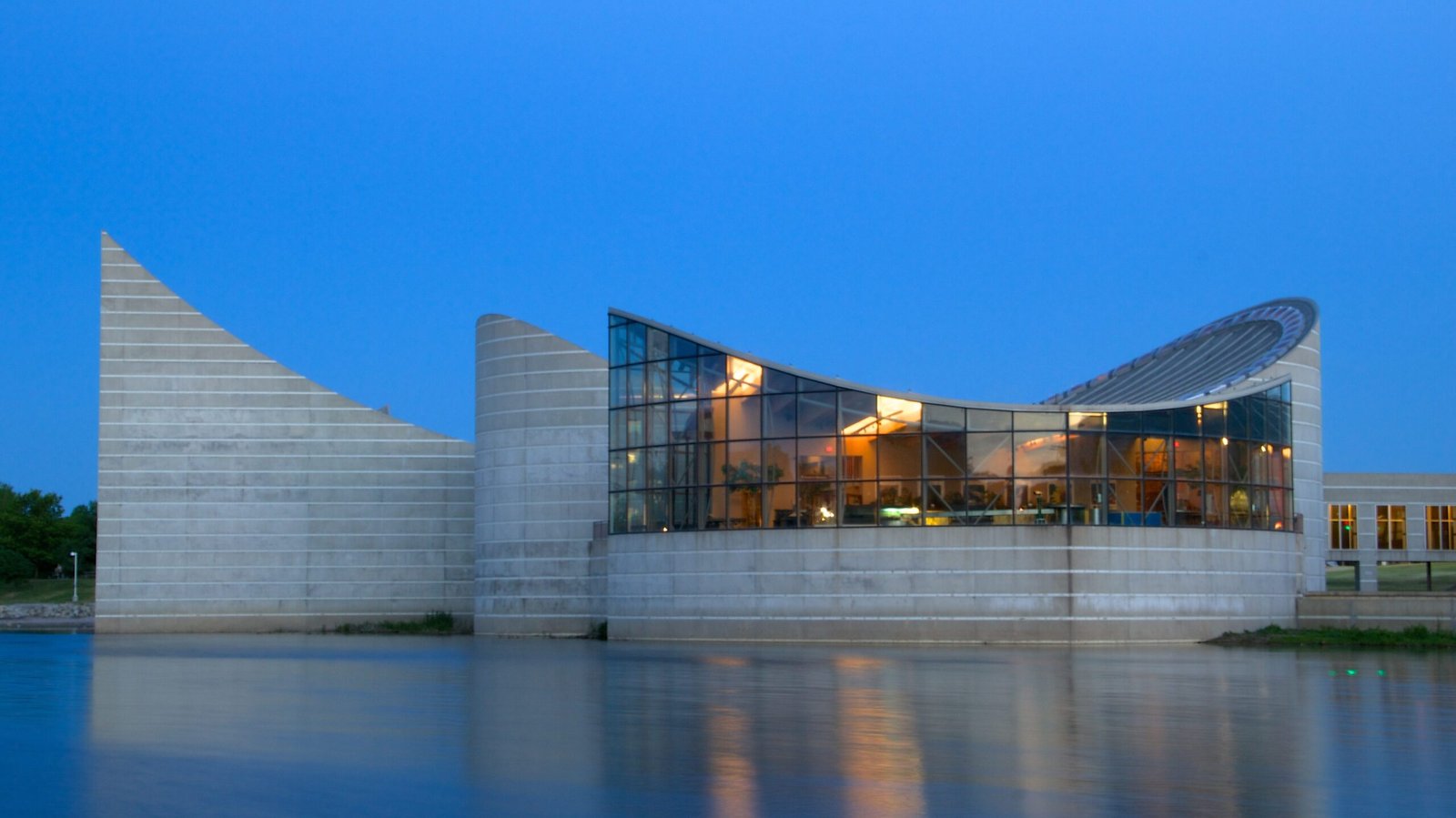Modern building with curved roof overlooking vast body of water. Pest control in Wichita keeps the city free of disease.